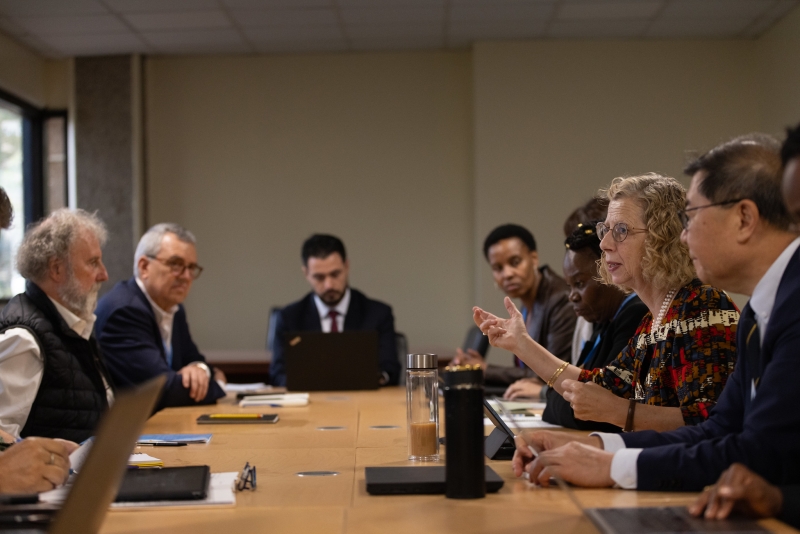 A woman speaking at a table surrounded by others. 