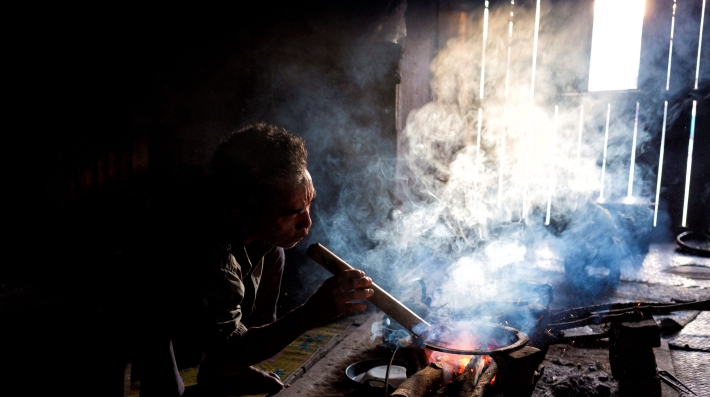 A man stoking a fire inside a house 