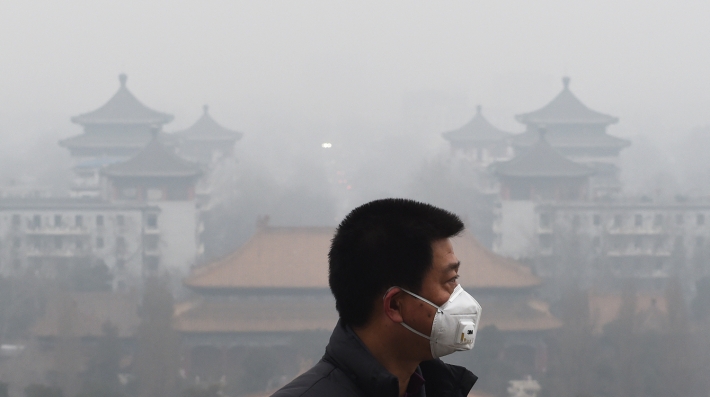 A man with a mask surrounded by air pollution 