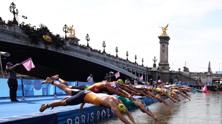 Swimmers diving en masse into a river