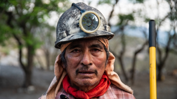 Foto de perfil de um homem com capacete de mineração