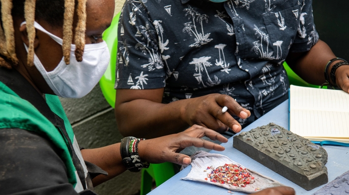 A woman holds a brick made from recycled plastic